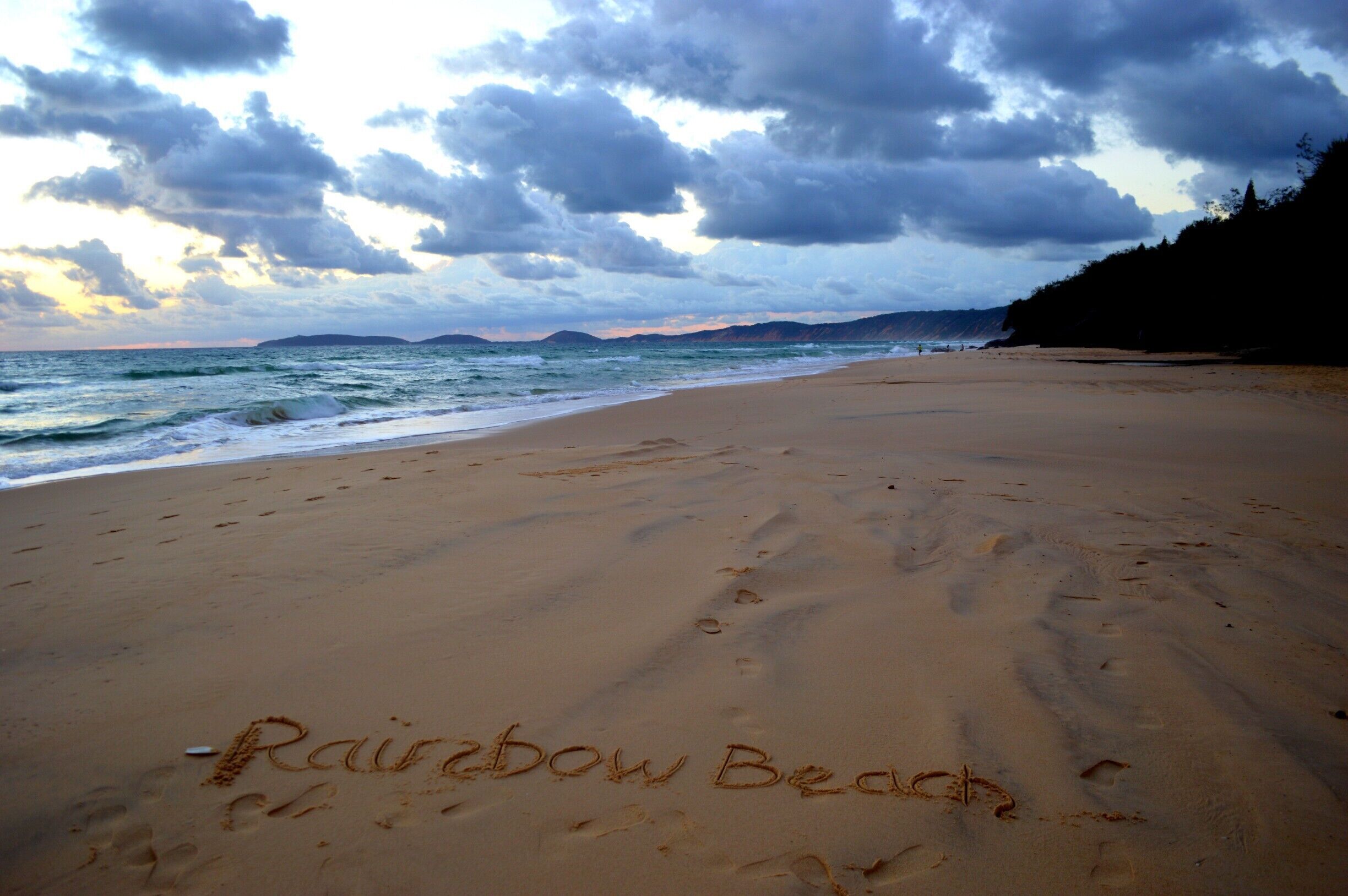 Even at 5am, Rainbow Beach is a stunning place to stay.  
The coloured sand dunes are still visible as the sun begins to lift over the waters edge.  A very special moment for my daughter and I as it was just us up and at the beach that morning.  