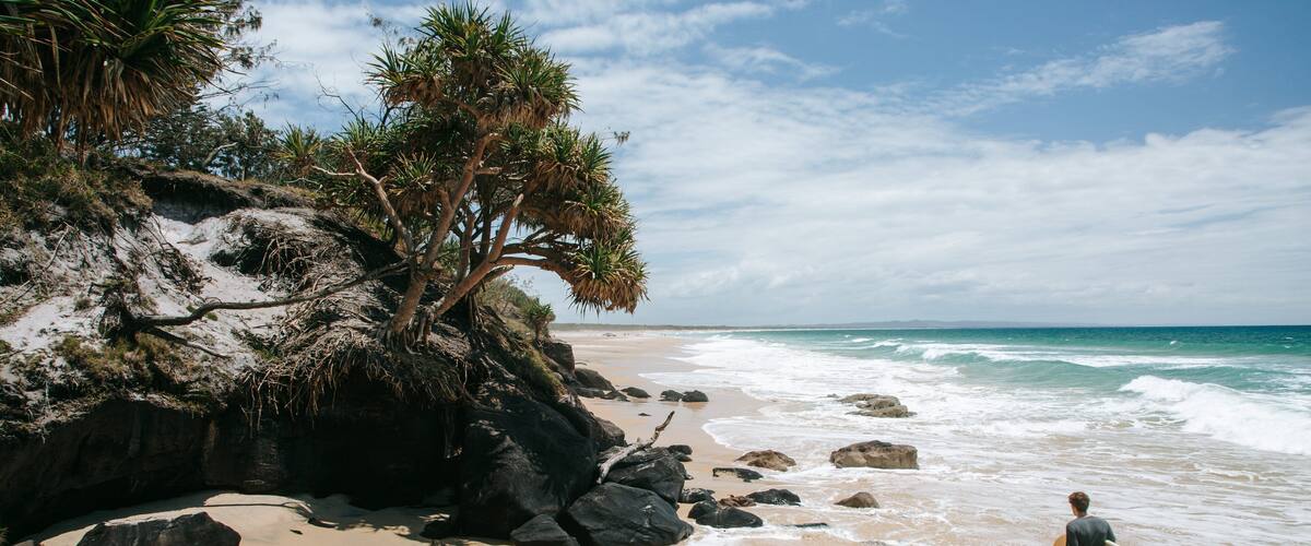 Rainbow Beach which includes general coastal views, a sandy beach and rocky coastline
