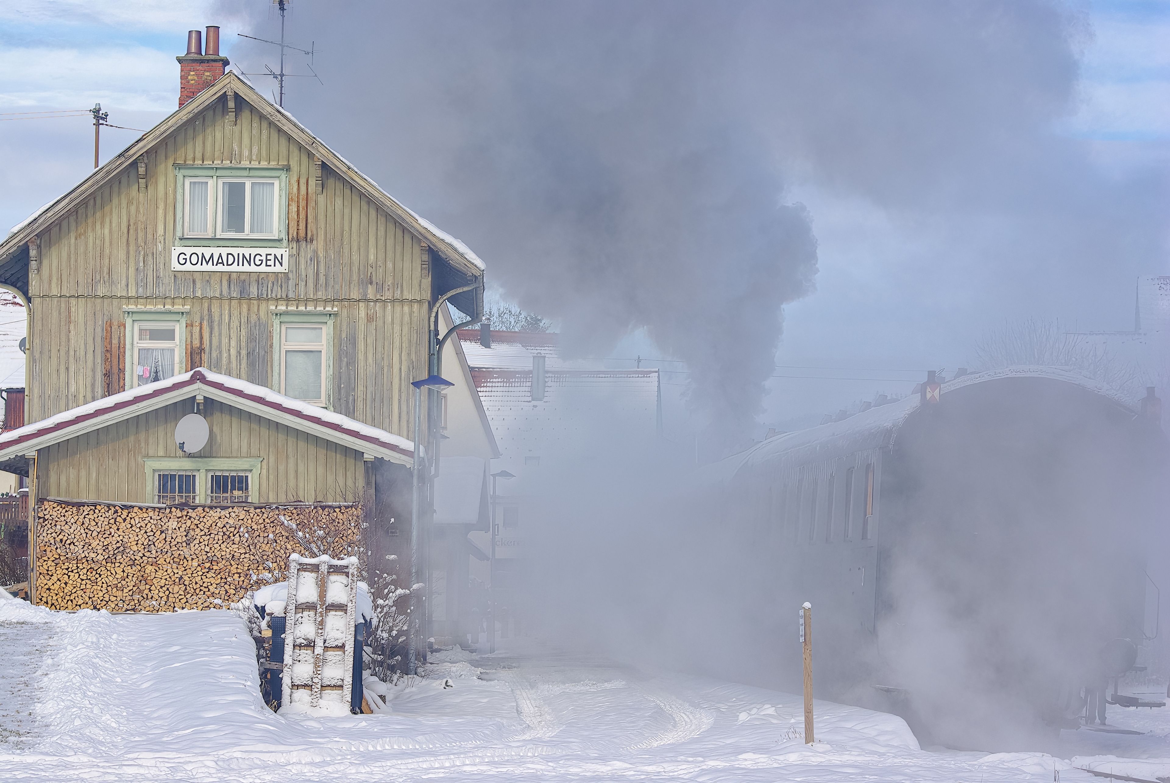 Snowy wintery railway station of Gomadingen with halting steam train, Gomadingen, Swabian Alb, Baden-Wurttemberg, Germany, November 28, 2010.