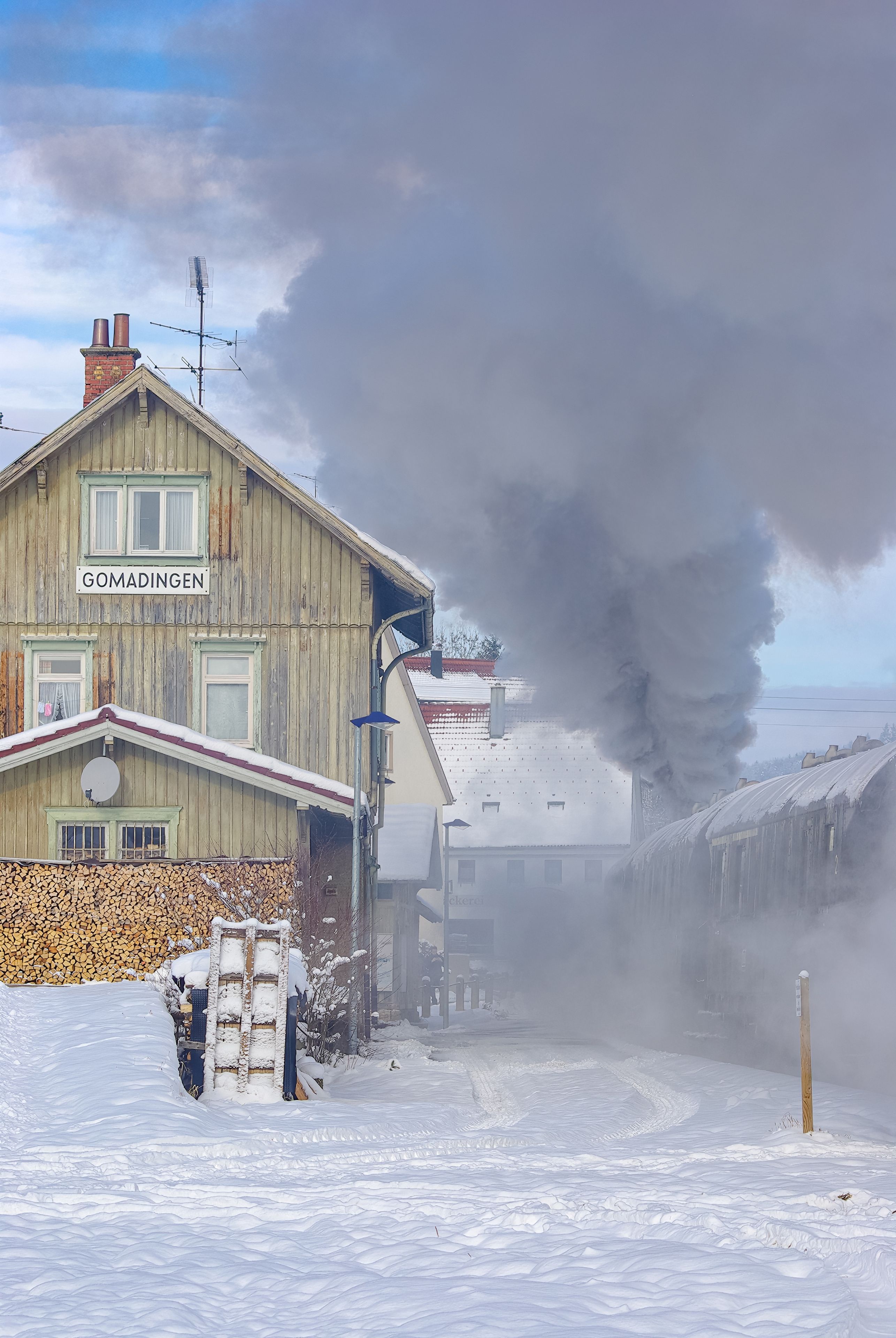 Snowy wintery railway station of Gomadingen with halting steam train, Gomadingen, Swabian Alb, Baden-Wurttemberg, Germany, November 28, 2010.