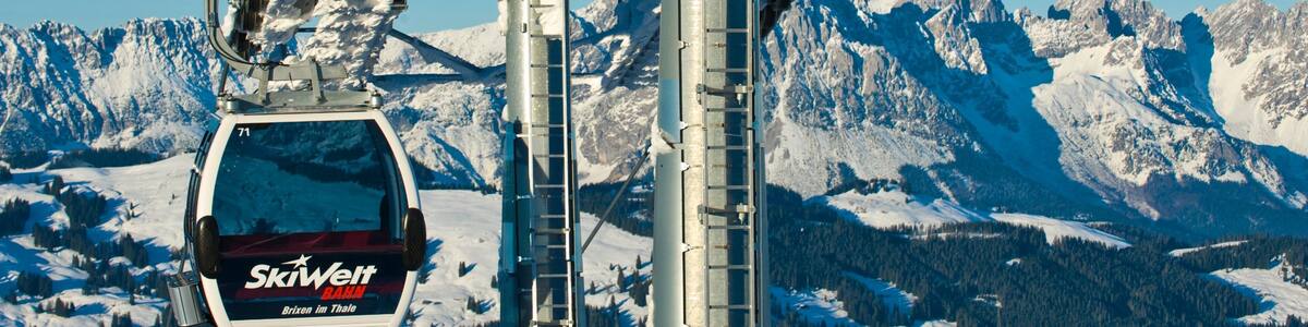 Eine Seilbahn mit Gondeln in verschneiter Berglandschaft.