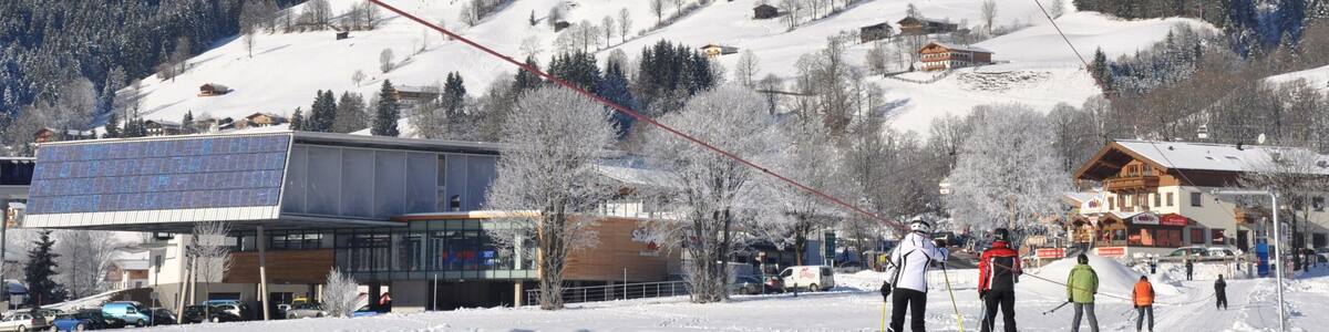 A snowy mountain landscape with ski resorts, buildings, and a ski lift.