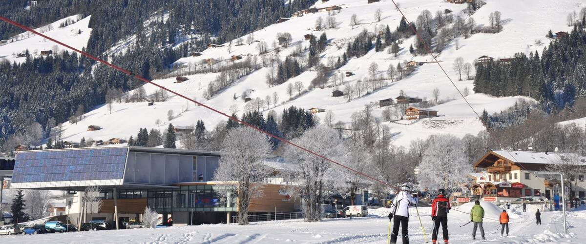 A snowy mountain landscape with ski resorts, buildings, and a ski lift.