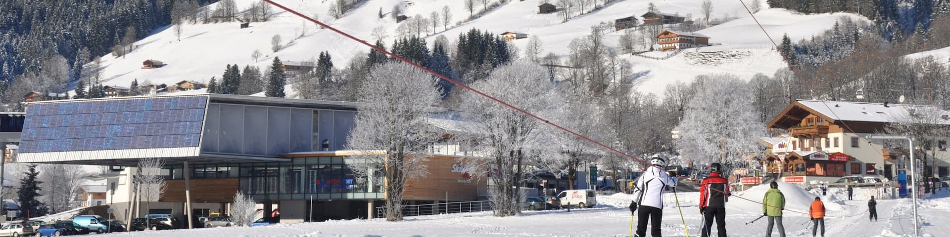 A snowy mountain landscape with ski resorts, buildings, and a ski lift.
