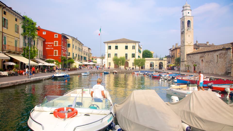 A canal with boats, a restaurant, and historic buildings.