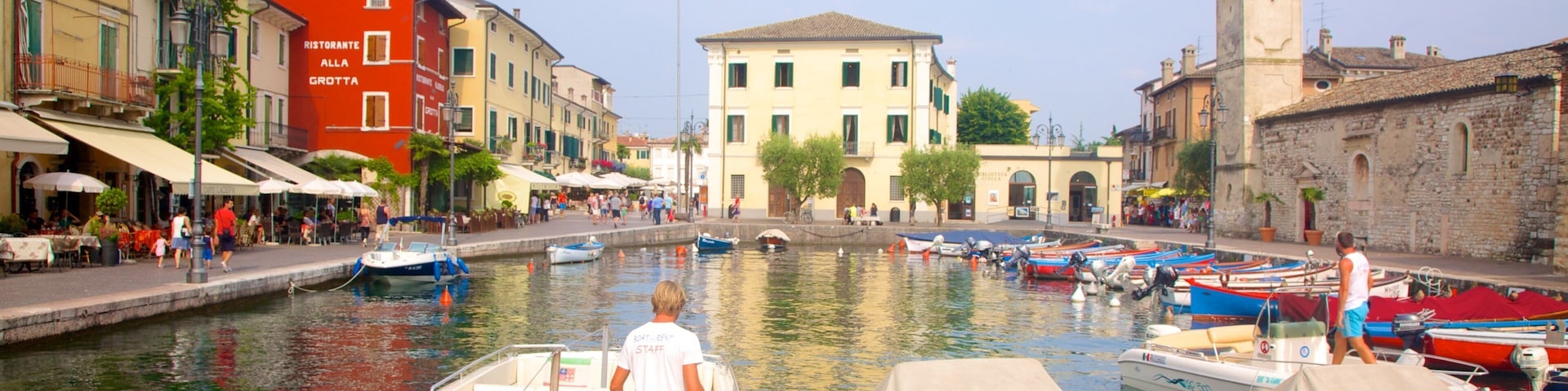 A canal with boats, a restaurant, and historic buildings.