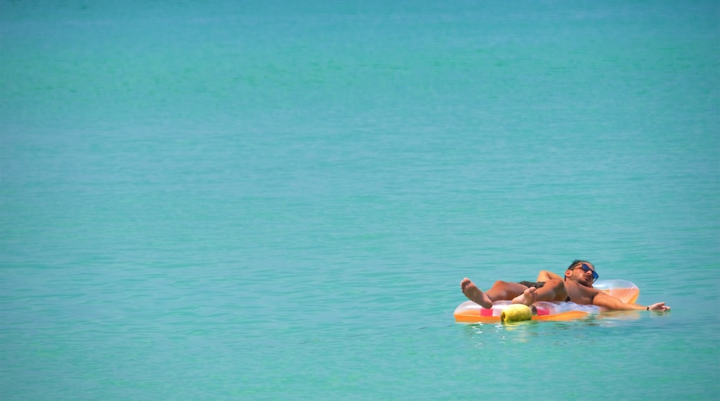Surin Beach which includes a bay or harbor and swimming as well as an individual male