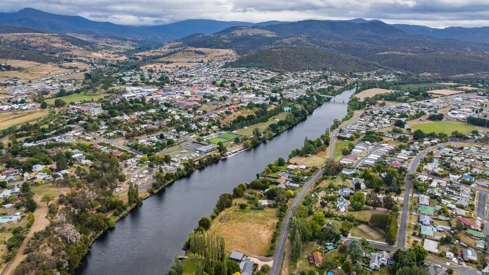 A river winding through a town surrounded by hills.