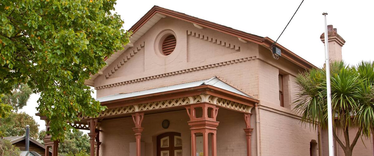 A historic building with a sign reading "Woodend Court House 1870".