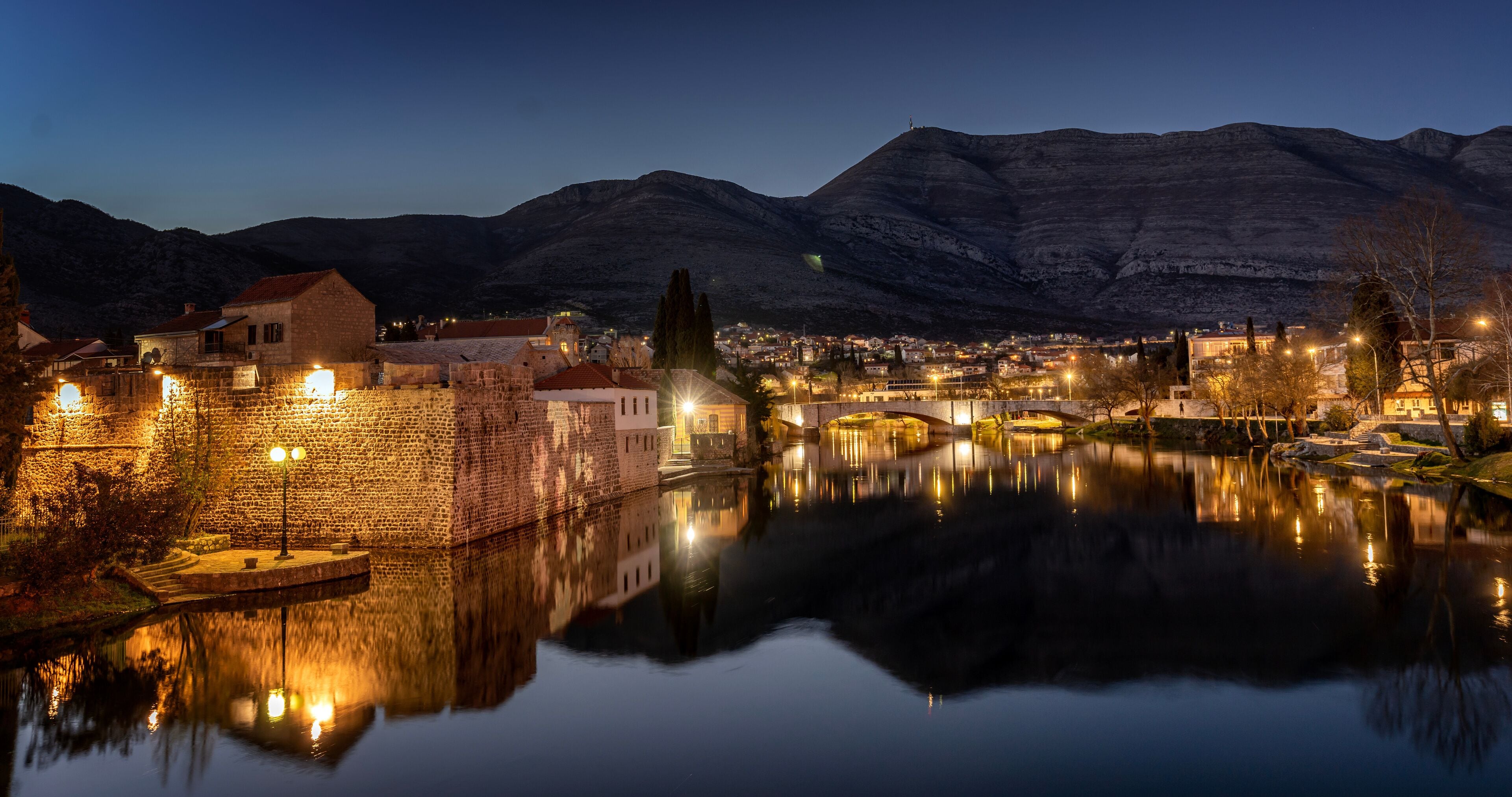 Night cityscape. Trebinje is a city in Bosnia and Herzegovina, the historical center of the city. Buildings are reflected in the river