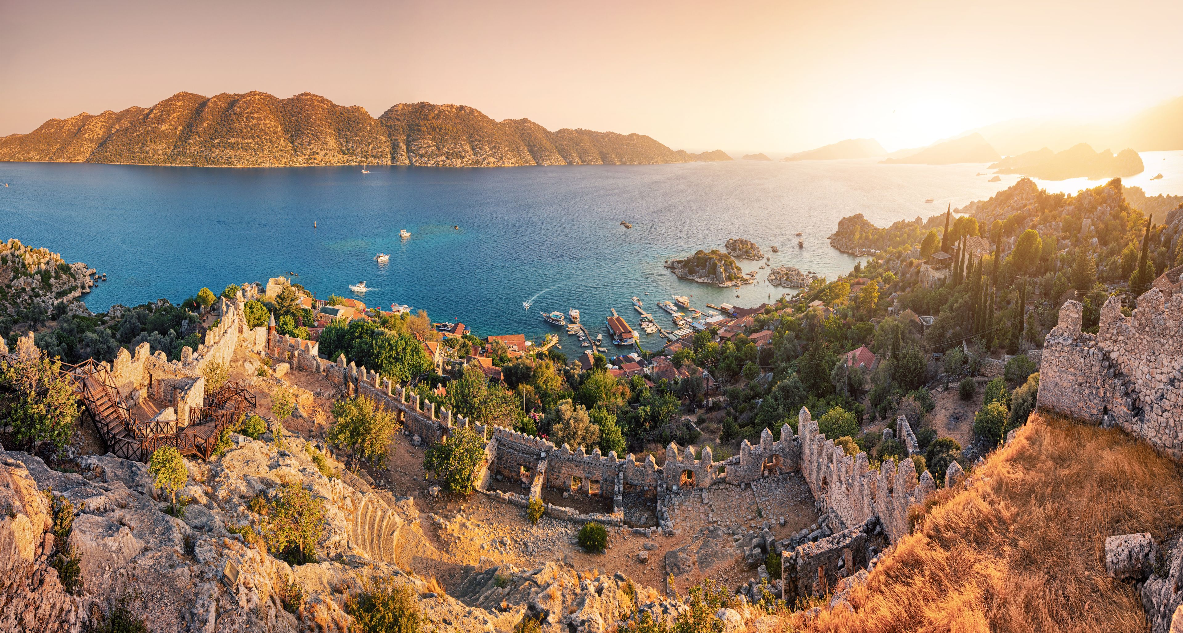 Famous Simena ancient castle on a top of a hill with stunning panoramic view over the sea at sunset time. Travel and tourist attractions at Kekova island, Turkey.