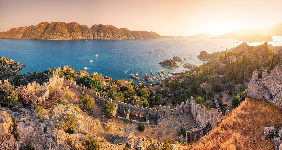 Famous Simena ancient castle on a top of a hill with stunning panoramic view over the sea at sunset time. Travel and tourist attractions at Kekova island, Turkey.