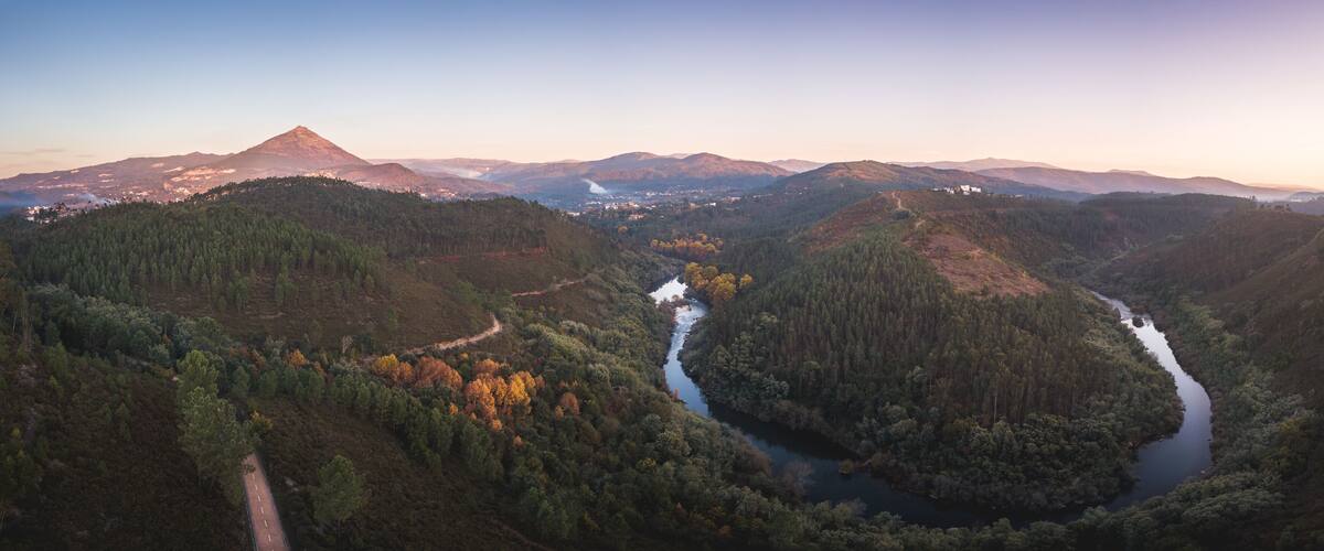A river winding through a valley with mountains in the background.