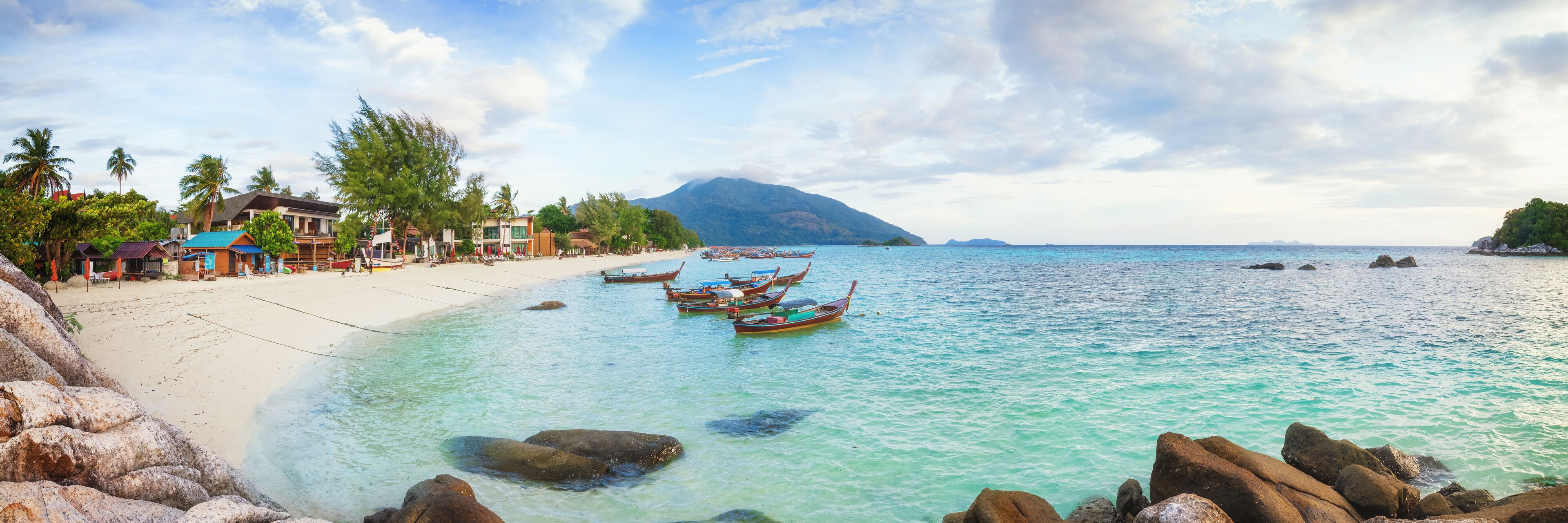 Panorama of Koh Lipe Sunrise Beach with rocks on foreground