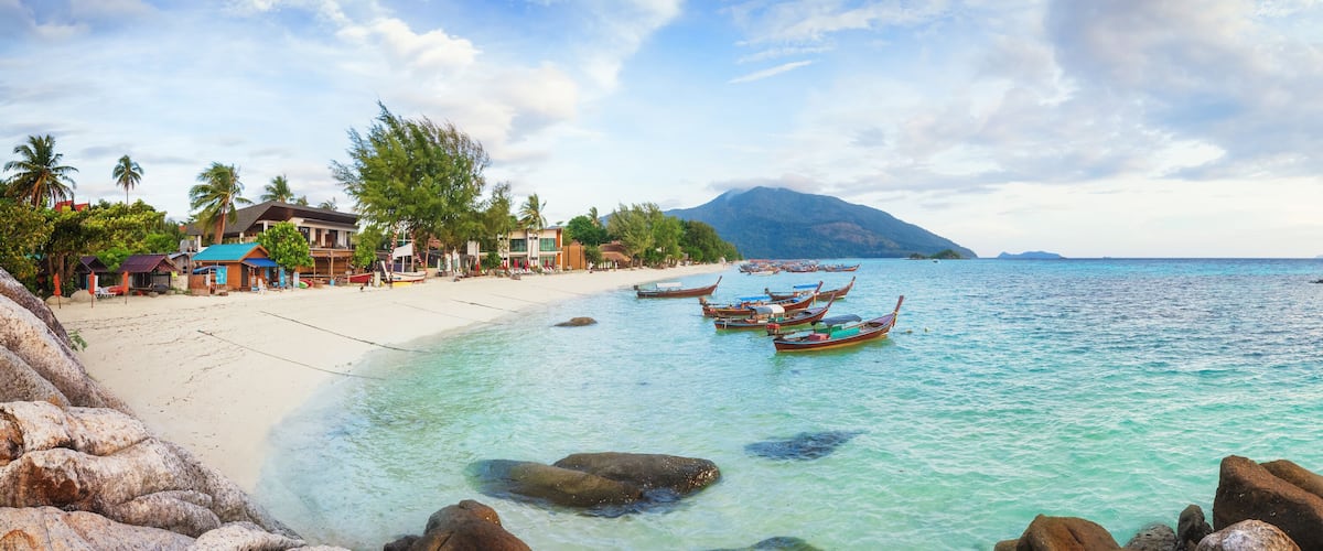 Panorama of Koh Lipe Sunrise Beach with rocks on foreground