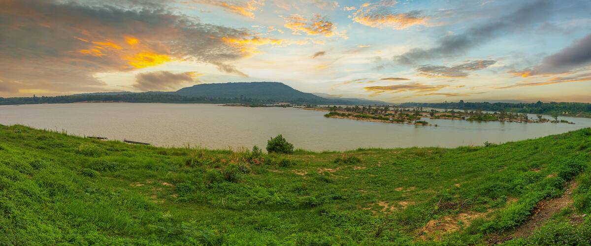 A lake with a distant mountain, surrounded by green fields.