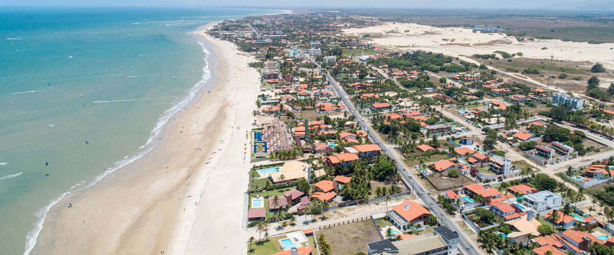 A coastal town with a beach, residential areas, and a distant cityscape.