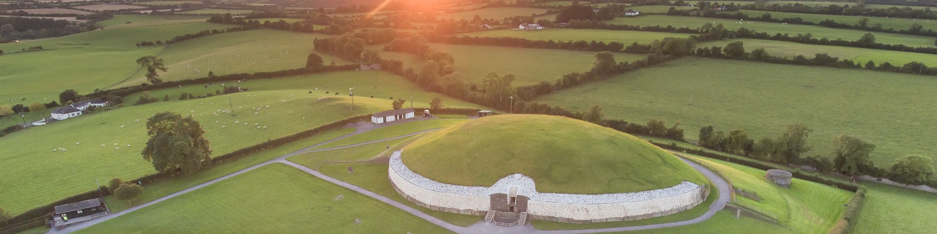 Aerial view of a sunset and surrounding farmland at the ancient passage tomb and temple of Newgrange, a Neolithic monument at the Bru na Boinne Heritage Site; Donore, County Meath, Ireland