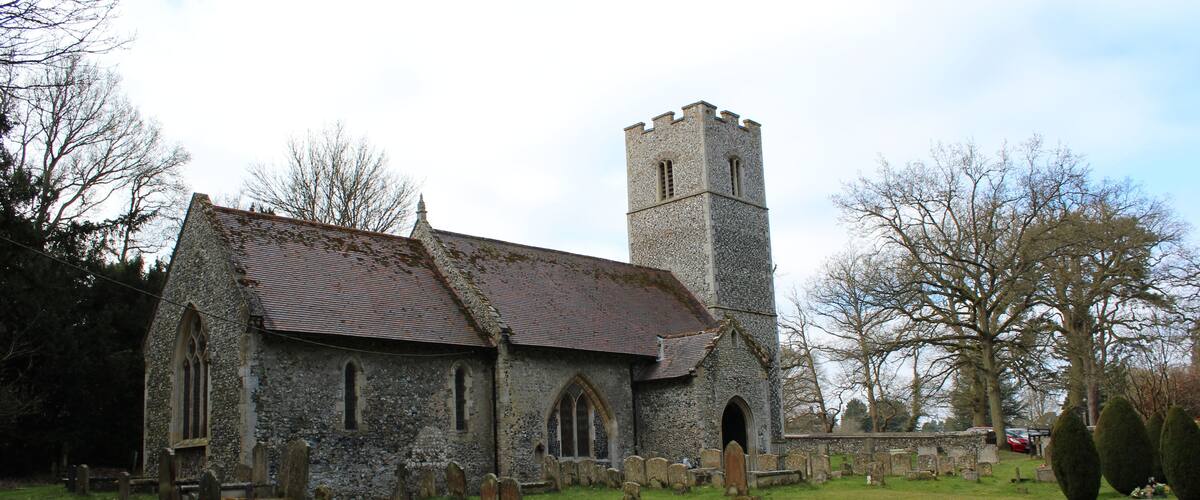 A church with a tower and a cemetery with gravestones.