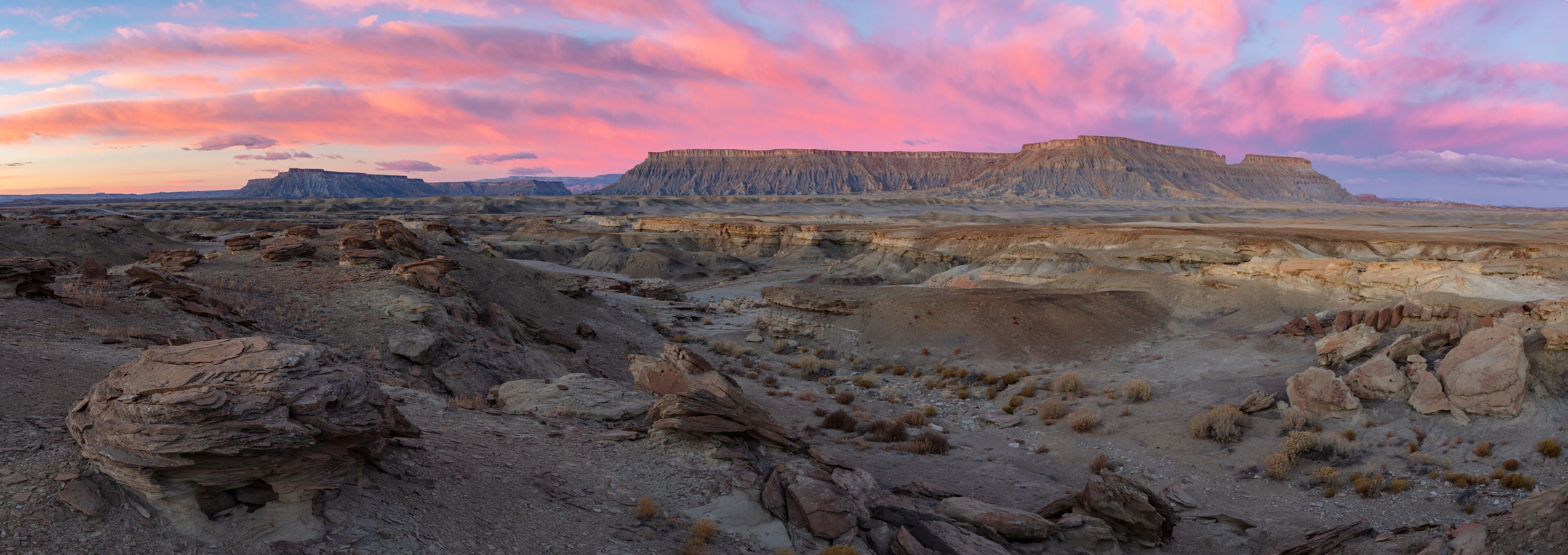 North Caineville Mesa and South Caineville Mesa rise above badland formations during a dramatic winter sunrise.  Located in the Blue Hills region of Utah near Capitol Reef National Park.