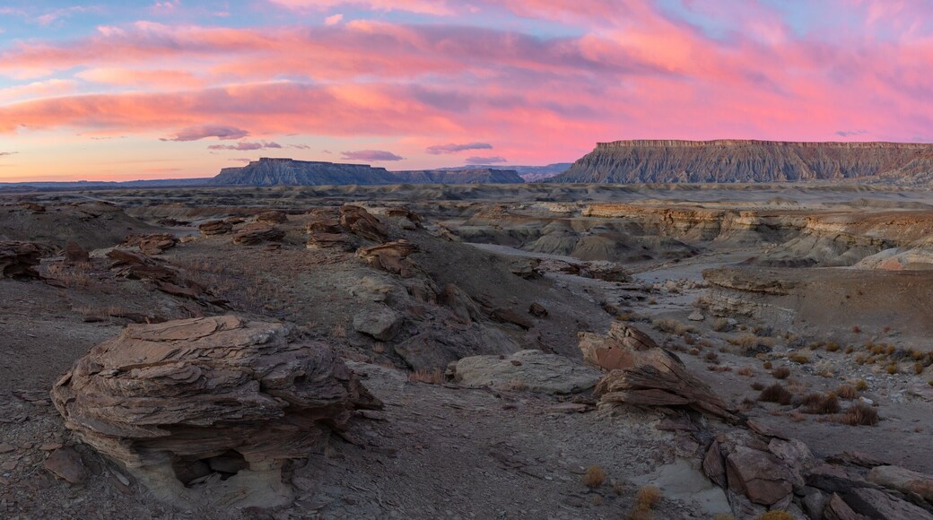 North Caineville Mesa and South Caineville Mesa rise above badland formations during a dramatic winter sunrise. Located in the Blue Hills region of Utah near Capitol Reef National Park.