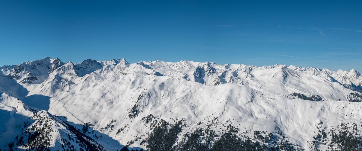 A snow-covered mountain range with clear blue skies.