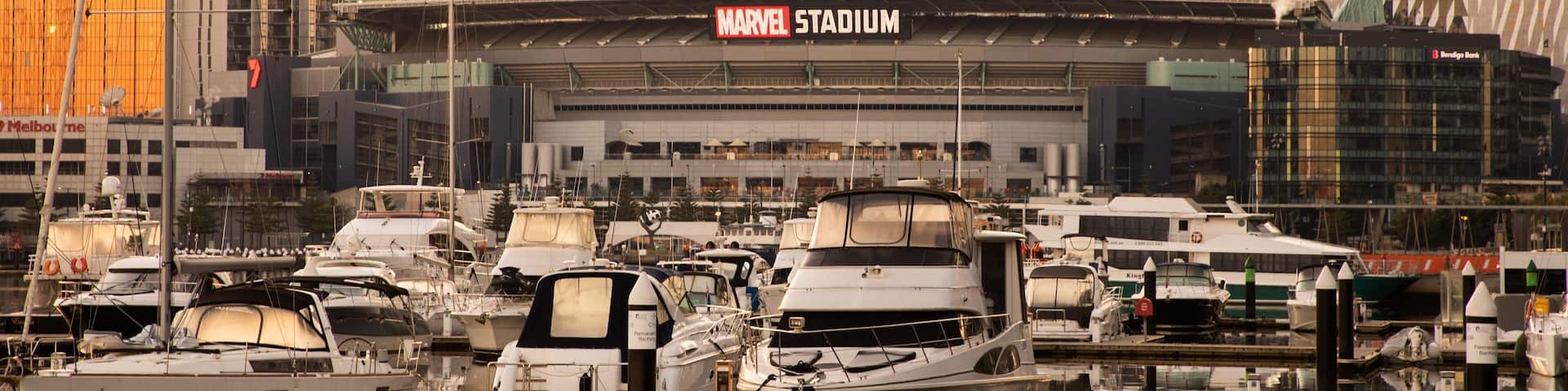 Marvel Stadium featuring a sunset, a bay or harbor and signage