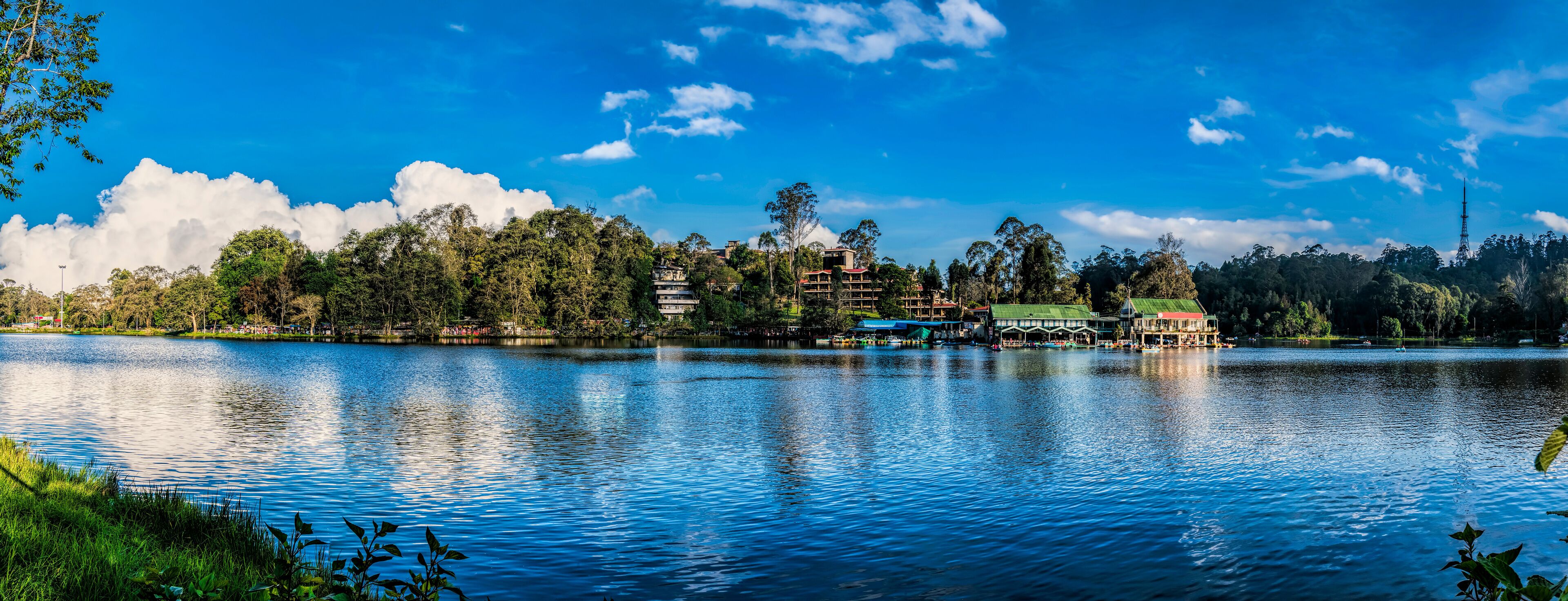 A lake with buildings and trees on the shore.