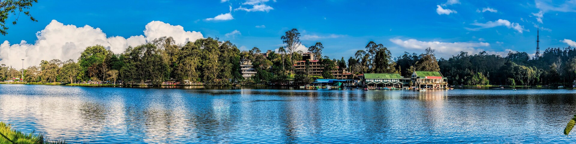 A lake with buildings and trees on the shore.