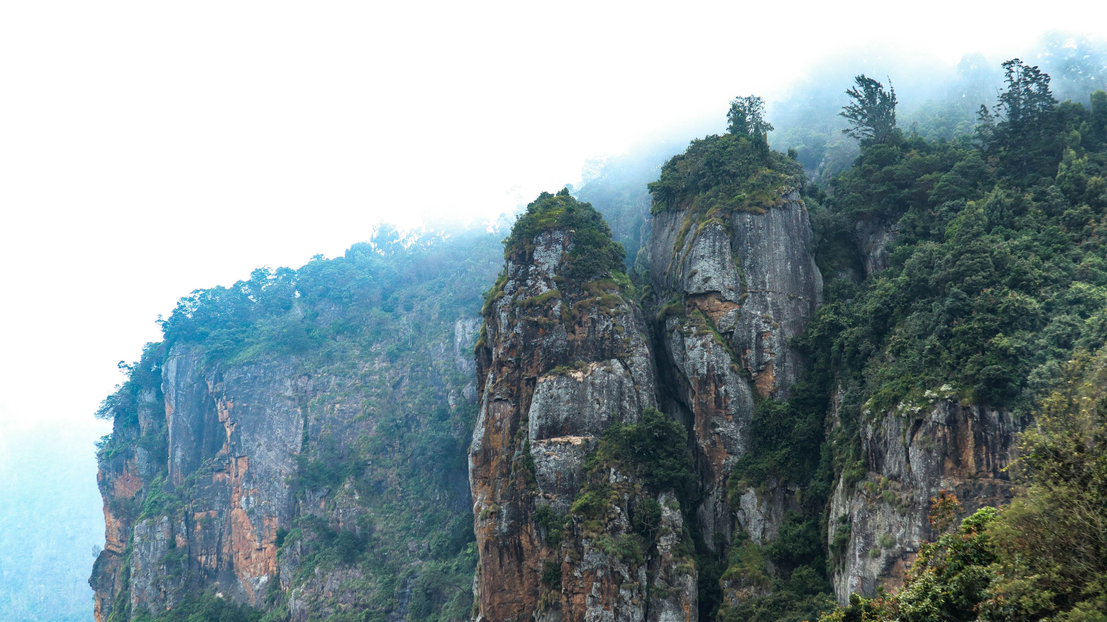 A mountainous landscape with towering rock formations covered in greenery.