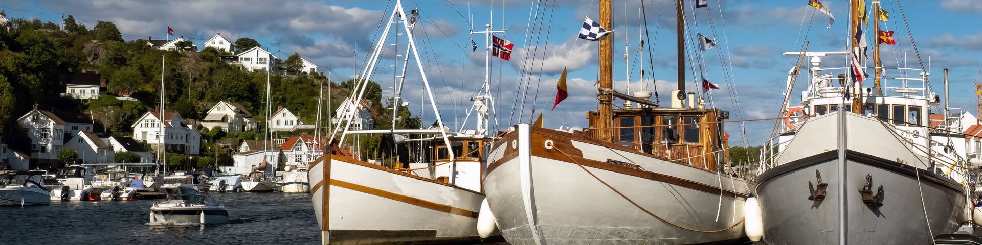 Tall ships in the old harbor of the historical seaside resort town of Risør on the southern coast of Norway.