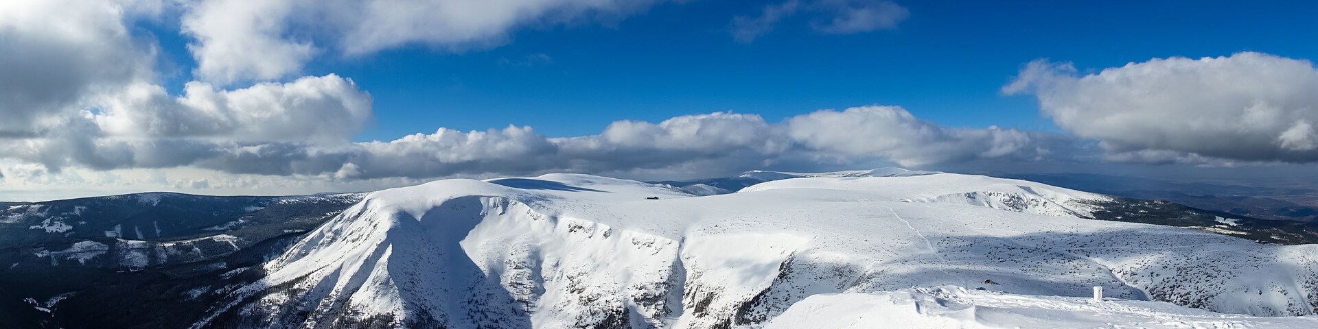 A snow-covered mountain range under a clear blue sky.