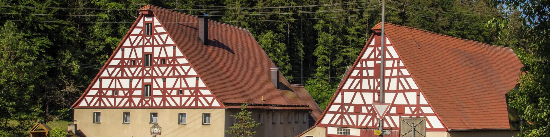 A rural German village with traditional half-timbered houses and a road leading to them.