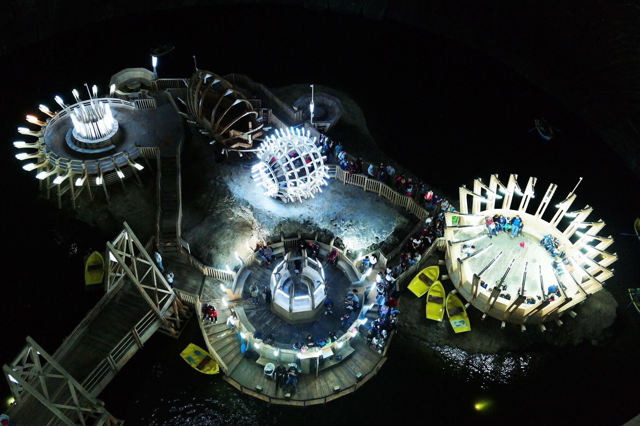 Terezia mine...

It is a conical mine (bell mine). Salt mining in this type of room left behind underground halls of impressive dimensions: 90 m height and 87 m diameter. The depth from the mouth of the shafts to the base of the mine is 112 m. A "cascade of salt", an underground lake, stalactites and salt efflorescences complete the inert equilibrium of the giant bell. The underground lake is between 0.5 and 8 m deep and is extended on about 80% of the operating room hearth area. In the center of the lake there is an island formed from residual salt deposited here after 1880, the year when salt mining ended in this room...