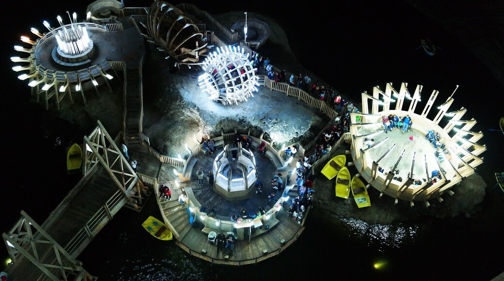Terezia mine...
It is a conical mine (bell mine). Salt mining in this type of room left behind underground halls of impressive dimensions: 90 m height and 87 m diameter. The depth from the mouth of the shafts to the base of the mine is 112 m. A "cascade of salt", an underground lake, stalactites and salt efflorescences complete the inert equilibrium of the giant bell. The underground lake is between 0.5 and 8 m deep and is extended on about 80% of the operating room hearth area. In the center of the lake there is an island formed from residual salt deposited here after 1880, the year when salt mining ended in this room...