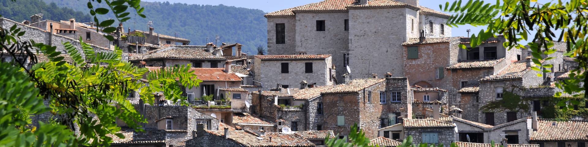 Village of Tourrettes sur Loup in southeastern France with leaves in the foreground, department des Alpes Maritimes