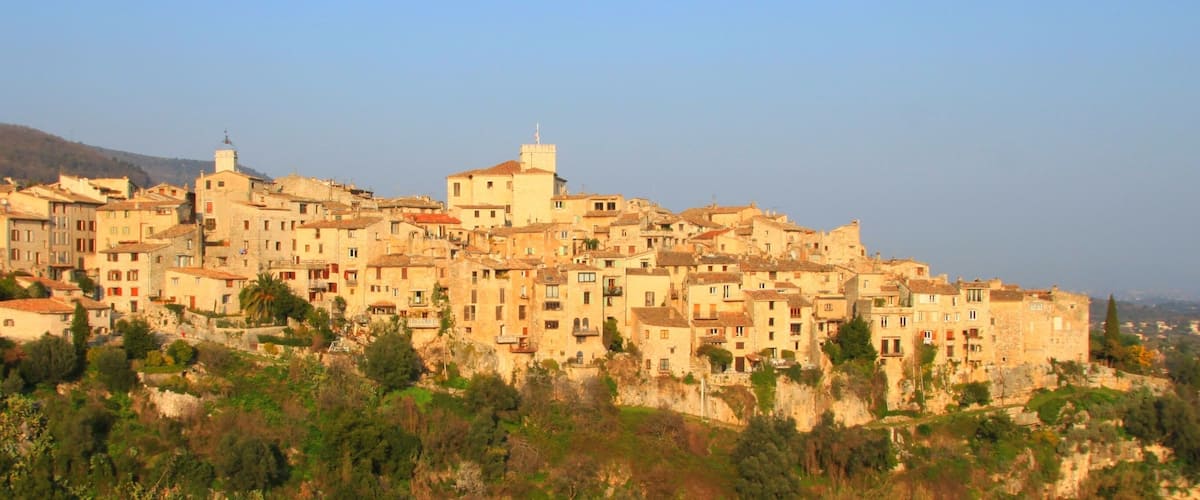 A historic town with stone buildings and a prominent church on a hillside.