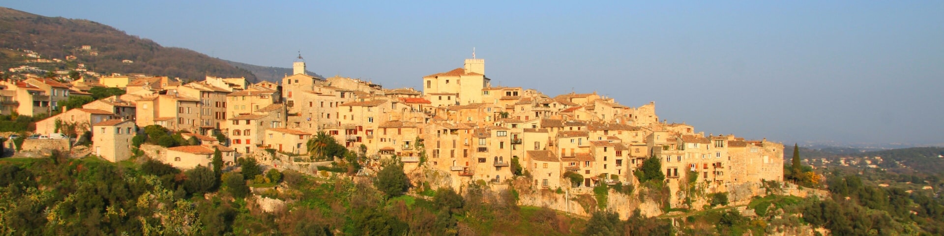 A historic town with stone buildings and a prominent church on a hillside.