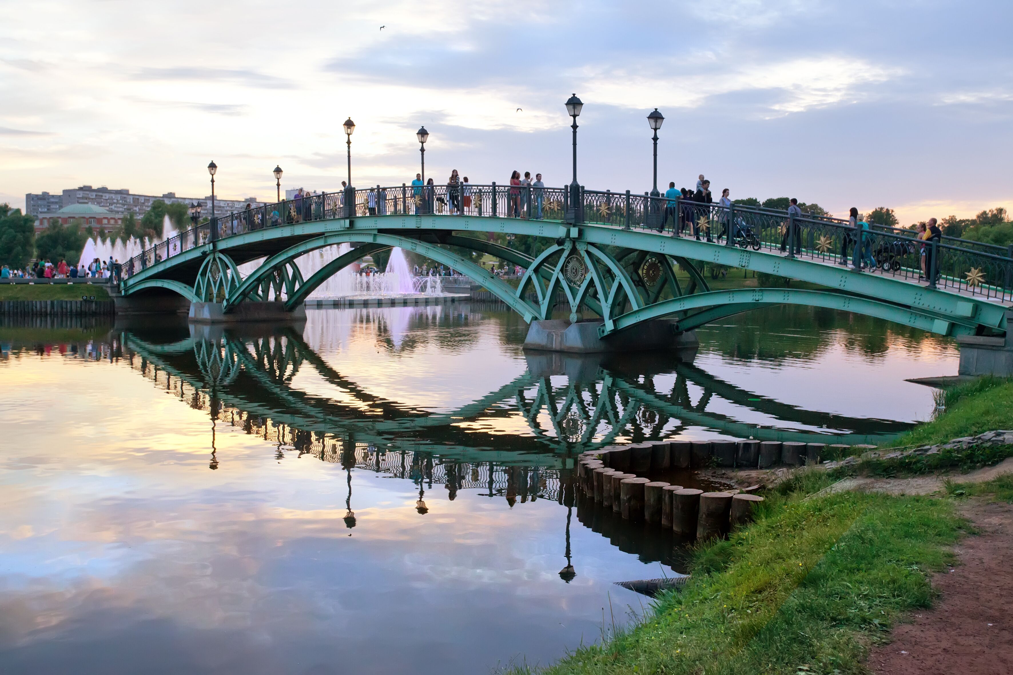 People walking on bridge over apond in park. Moscow.