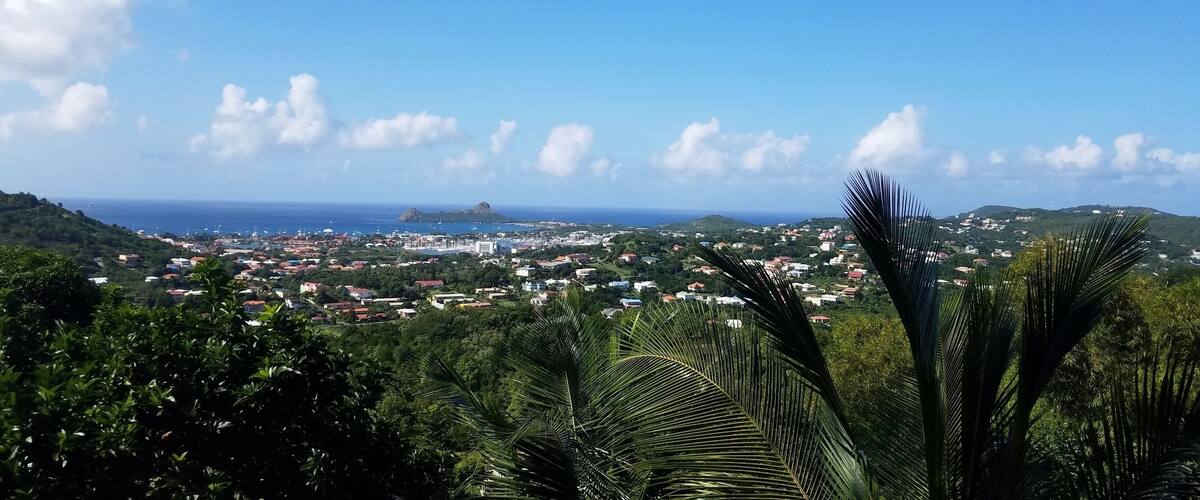 A coastal town with a view of the ocean and hills in the distance.