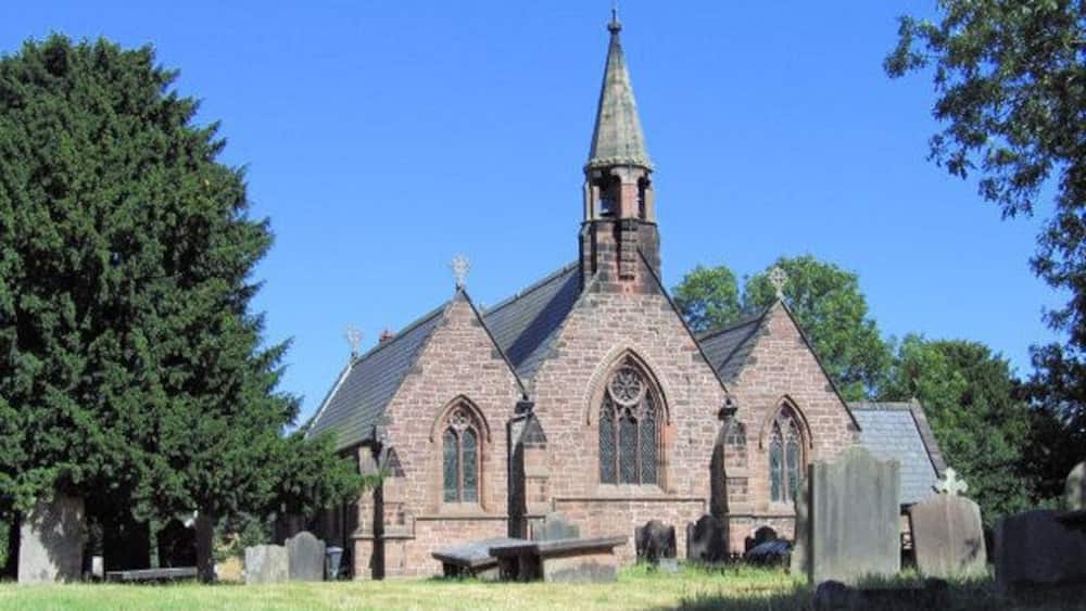 Une église dotée d’un clocher élancé et d’une tour horloge.