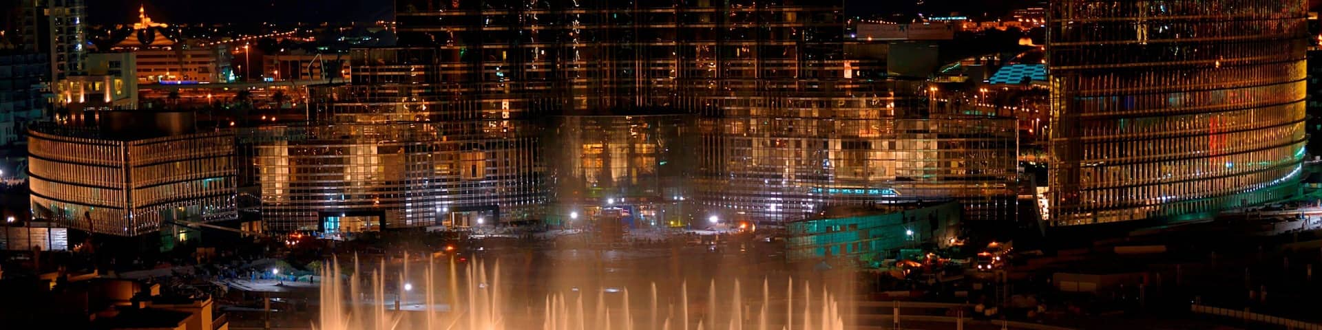 The Dubai Fountain featuring a bridge, a fountain and night scenes