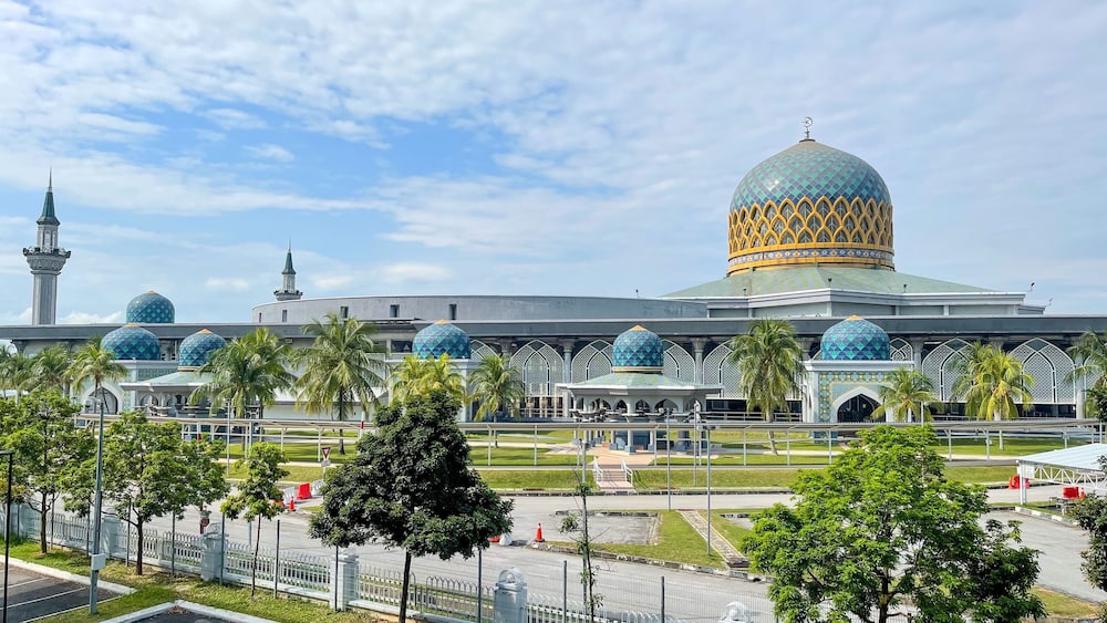 Eine Moschee mit mehreren Kuppeln und einem Minarett.