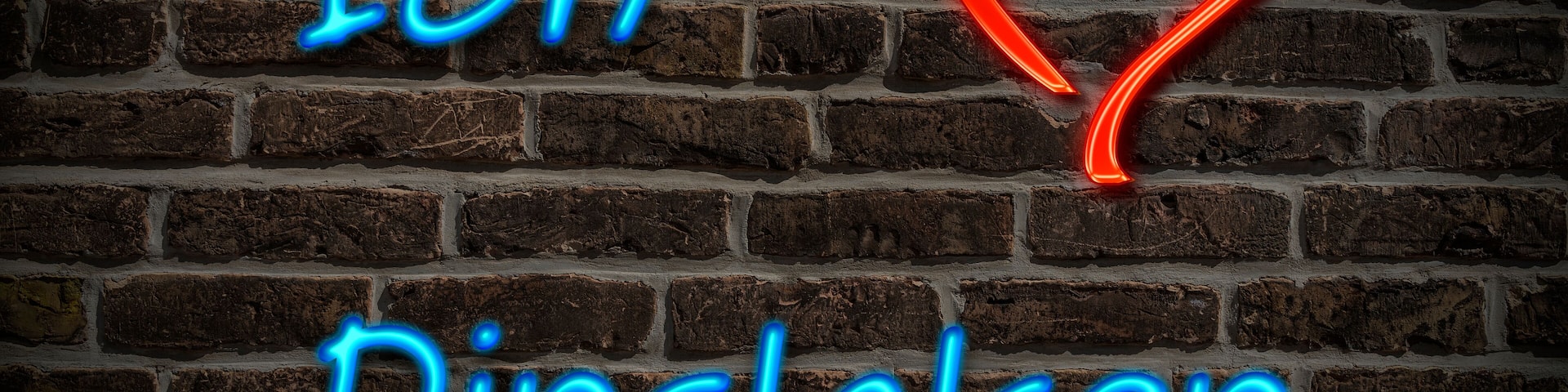 A neon sign with the text "Ich Dinslagen" and a heart symbol on a brick wall.