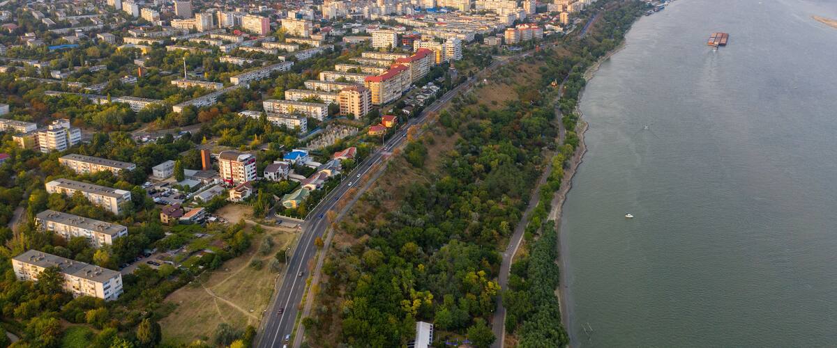 Aerial view of Galati City, Romania. Danube River near city with sunset warm light
