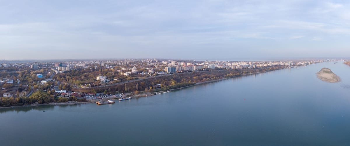 A river flowing through a city with buildings and trees along the banks.