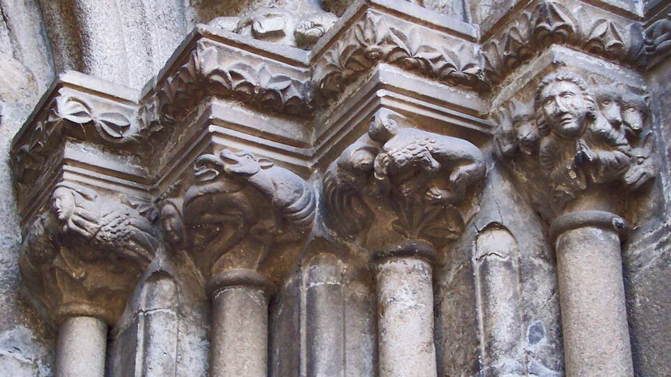 Detallados grabados de leones y motivos florales en una columna.