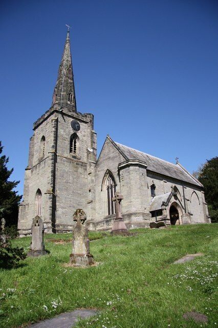 An old stone church with a tall spire and a clock tower.