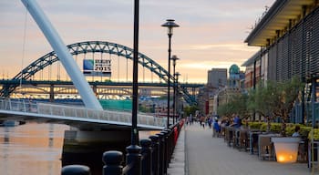 Quayside caracterizando um pôr do sol, cenas de cafeteria e um rio ou córrego