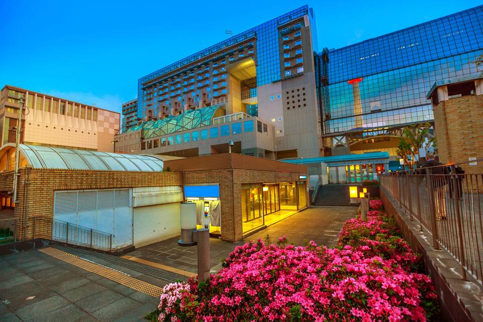 A modern urban building complex with glass facades and a covered pedestrian walkway.